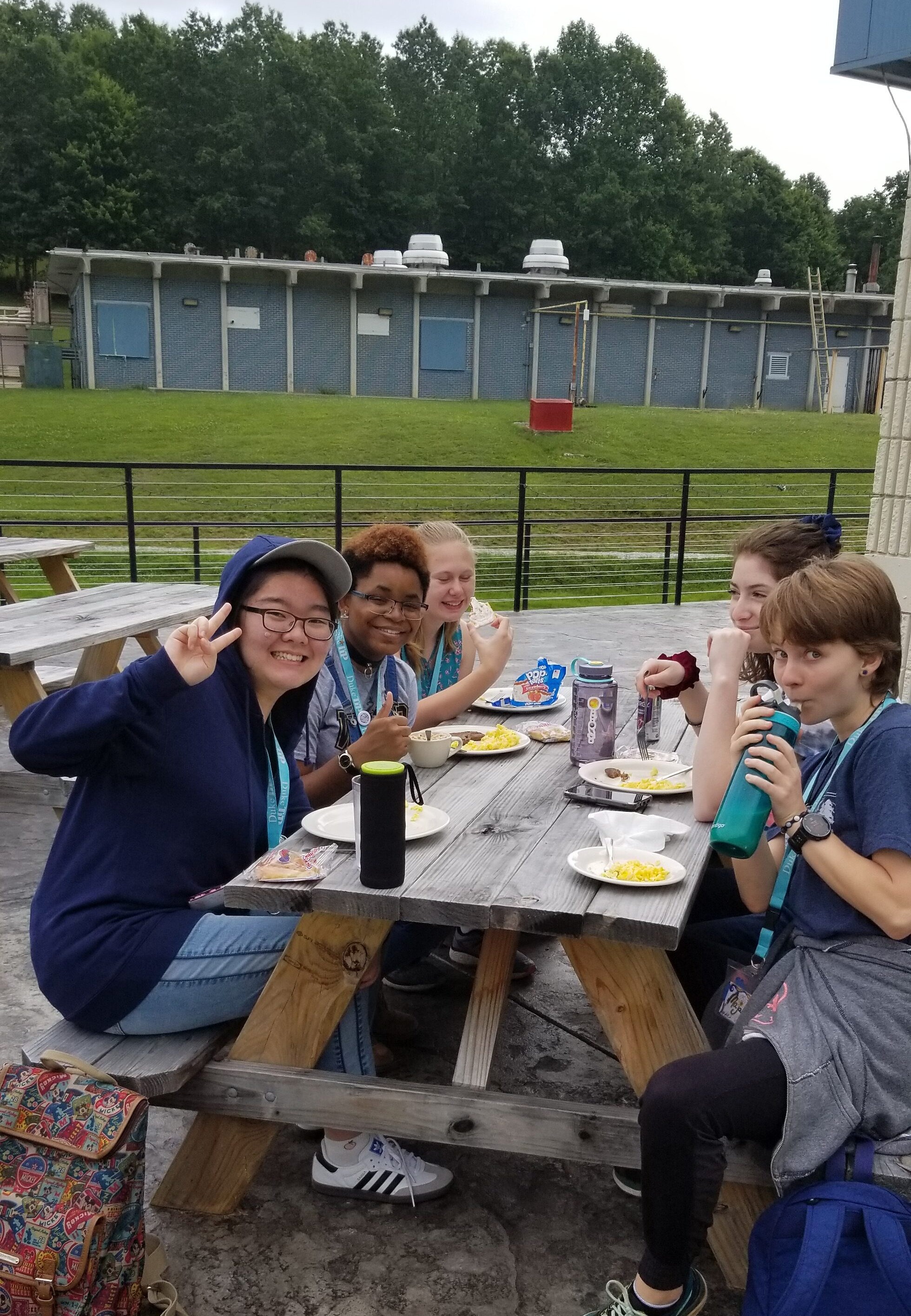 people sitting at a picnic table on the deck